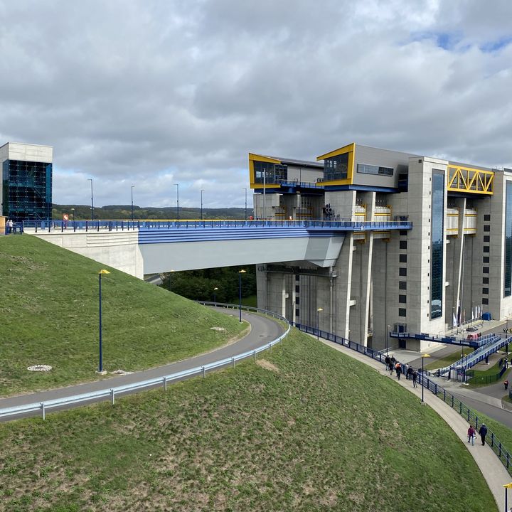 Elevated side view of the new Niederfinow ship lift with its access bridge, grass-covered embankments and the adjoining canal.